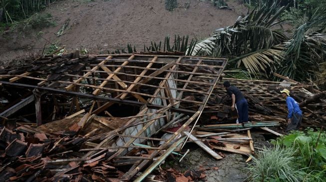 Petugas dan warga membereskan puing-piung rumah akibat tanah longsor di Desa Sukamulya, Talegong, Kabupaten Garut, Jawa Barat, Kamis (3/12/2020).  [ANTARA FOTO/Candra Yanuarsyah]