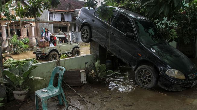 Sebuah mobil tersangkut di pagar pascabanjir di Perumahan De Flamboyan, Medan, Sumatera Utara, Jumat (4/12/2020).  [ANTARA FOTO/Rony Muharrman]