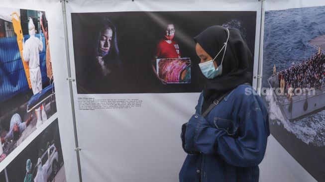 Seorang lengunjung mengamati karya di pameran fotografi Rekam Jakarta 2020 di Thamrin 10, Jakarta Pusat, Sabtu (5/12). [Suara.com/Alfian Winanto]