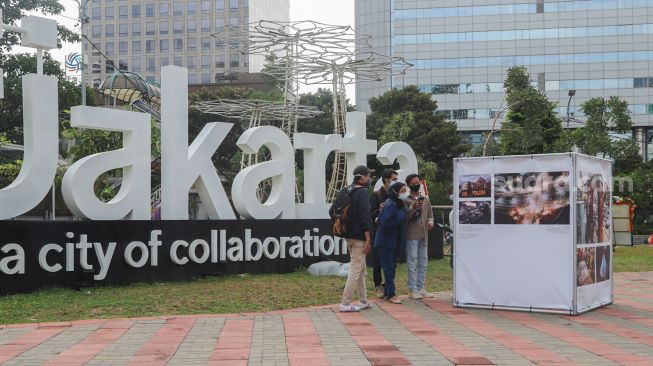 Pengunjung mengamati karya di pameran fotografi Rekam Jakarta 2020 di Thamrin 10, Jakarta Pusat, Sabtu (5/12). [Suara.com/Alfian Winanto]