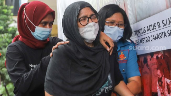 Sambil menangis, mantan Penyanyi cilik Ratna Fairuz Albar atau Iyut Bing Slamet dibawa kembali masuk ke dalam saat gelar konferensi pers kasus narkotika yang melibatkan dirinya di Polres Metro Jakarta Sekatan, Sabtu, (5/12). [Suara.com/Alfian Winanto]