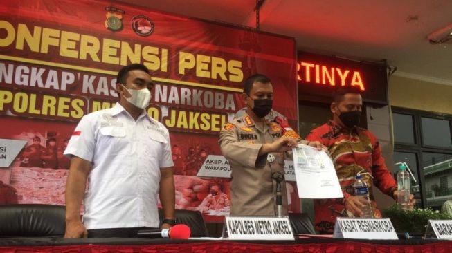 Kapolres Metro Jakarta Selatan Kombes Pol Budi Sartono (tengah) memperlihatkan barang bukti hasil tes urine terhadap artis Iyut Bing Slamet yang dinyatakan positif metafetamin, dalam ekspose kasus di Mako Polres Metro Jakarta Selatan, Sabtu (5/12/2020). [Antara/Laily Rahmawati]