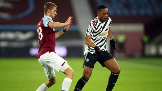 Penyerang Manchester United, Anthony Martial (kiri) tampil pada laga Liga Inggris 2020/2021 kontra West Ham United di London Stadium, Minggu (6/12/2020). [JULIAN FINNEY / POOL / AFP]