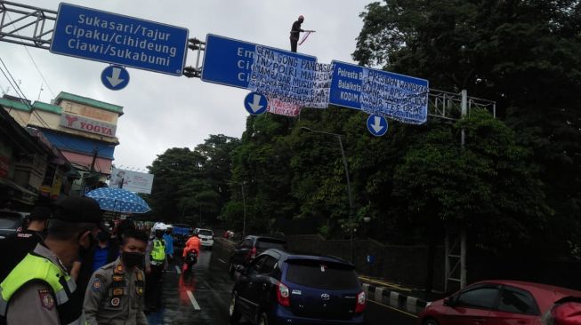 Pria Asal NTT Nekat Panjat Tiang Penunjuk Arah di Jalan Otista Bogor