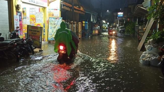 Hujan deras disertai angin kencang menyebabkan banjir di Kota Surabaya, Sabtu (5/12/2020) / [Foto Suara.com: Achmad Ali]