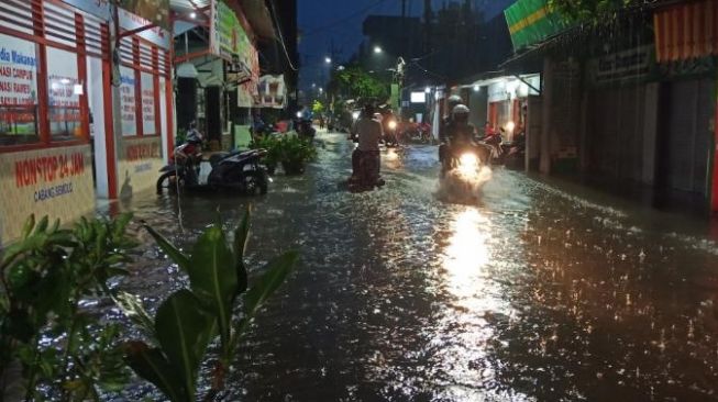 Hujan deras disertai angin kencang menyebabkan banjir di Kota Surabaya, Sabtu (5/12/2020) / [Foto Suara.com: Achmad Ali]