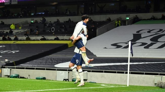 Penyerang Tottenham Hotspur Harry Kane merayakan gol bersama rekan satu timnya, Son Heung-min saat menghadapi Arsenal di pekan ke-11 Liga Inggris di Tottenham Hotspur Stadium, Minggu (6/12/2020) malam WIB. [Glyn KIRK / POOL / AFP]