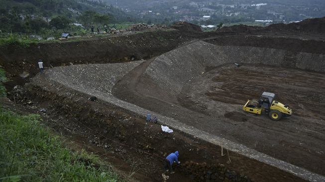 Pekerja menyelesaikan pembangunan tempat pemusnahan sampah modern (Sanitary Landfill) di TPA Pasir Bajing, Banyuresmi, Kabupaten Garut, Jawa Barat, Senin (7/12/2020). [ANTARA FOTO/Candra Yanuarsyah]