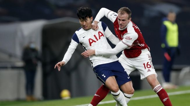 Penyerang Tottenham Hotspur Son Heung-min berebut bola dengan bek Arsenal Rob Holding di laga pekan ke-11 Liga Inggris di Tottenham Hotspur Stadium, Minggu (6/12/2020) malam WIB. [PAUL CHILDS / POOL / AFP]