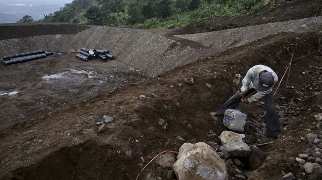 Pekerja menyelesaikan pembangunan tempat pemusnahan sampah modern (Sanitary Landfill) di TPA Pasir Bajing, Banyuresmi, Kabupaten Garut, Jawa Barat, Senin (7/12/2020). [ANTARA FOTO/Candra Yanuarsyah]