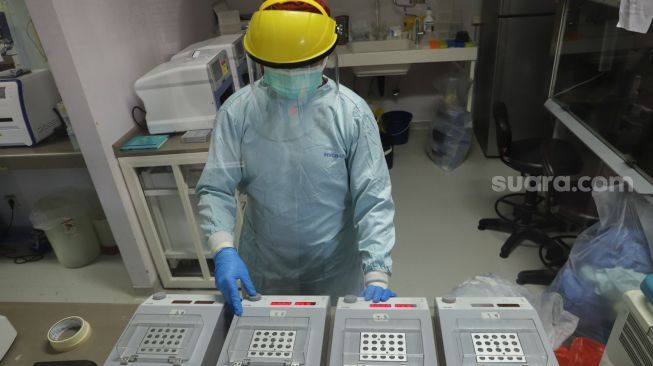 Petugas laboratorium memeriksa sampel hasil swab test Covid-19 di PRVKP FKUI, Jakarta, Senin (7/12/2020). [Suara.com/Alfian Winanto]