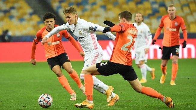 Gelandang Real Madrid Martin Odegaard coba mempertahankan bola dari para pemain Shakhtar Donetsk di laga Grup B Liga Champions di Olimpiyskiy stadium, 1 Desember 2020. [Sergei SUPINSKY / AFP]