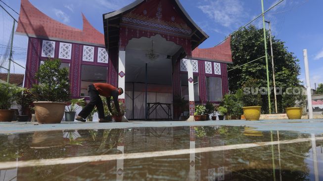 Petugas mempersiapkan Tempat Pemungutan Suara (TPS) dengan nuansa adat Padang di Kampung Benda Barat, Kelurahan Cipayung, Kota Depok, Jawa Barat, Selasa (8/12/2020). [Suara.com/Angga Budhiyanto]