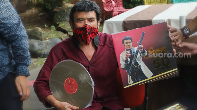 Pedangdut Rhoma Irama menunjukkan album piringan hitam golden edition dalam rangka perayaan 50 tahun berkarya dengan Soneta Grup di Depok, Jawa Barat, Selasa (8/12). [Suara.com/Alfian Winanto]