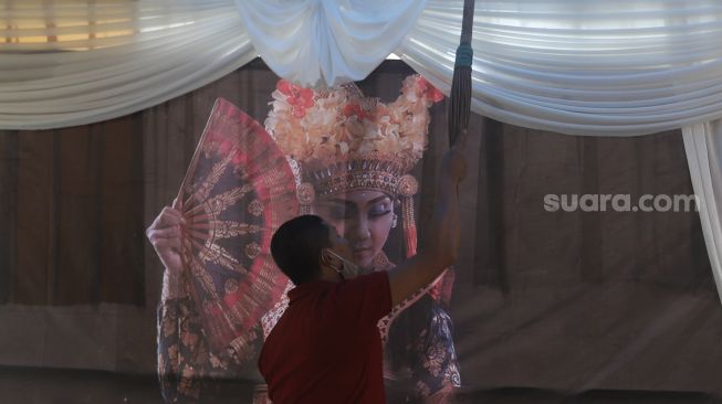 Petugas mempersiapkan Tempat Pemungutan Suara (TPS) dengan nuansa adat Bali di Kampung Benda Barat, Kelurahan Cipayung, Kota Depok, Jawa Barat, Selasa (8/12/2020). [Suara.com/Angga Budhiyanto]