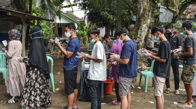 Sejumlah warga mengantre untuk memberikan hak pilihnya sambil memakai sarung tangan plastik sekali pakai di TPS 02, Desa Pananjung, Kabupaten Pangandaran, Jawa Barat, Rabu (9/12/2020).  [ANTARA FOTO]
