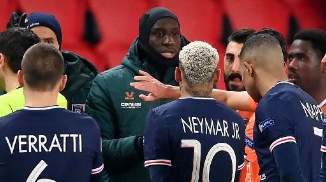 Pemain Istanbul Basaksehir, staf, dan pemain PSG mendatangi wasit akibat adanya dugaan rasial oleh ofisial pertandingan terhadap ofisial Basaksehir dalam laga pamungkas Liga Champions di Stadion Parc de Princes, Rabu (9/12/2020). [AFP]