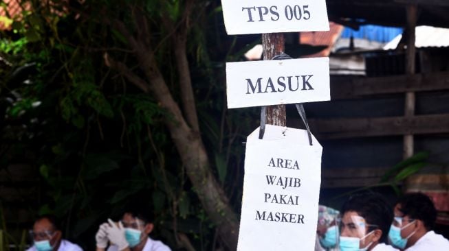 Imbauan penerapan protokol kesehatan dipasang di pintu masuk TPS 005 Desa Ibul Besar III, Kecamatan Pemulutan, Kabupaten Ogan Ilir. (matakamera/fornews.co/mushaful imam)