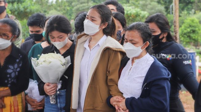 Tangis haru saudara kembar Melisha, Melitha Sidabutar dan sang ibu saat pemakaman Penyanyi Melisha Priscilla Sidabutar atau Melisha Idol di TPU Padurenan, Bekasi, Jawa Barat, Kamis (10/12). [Suara.com/Alfian Winanto] 