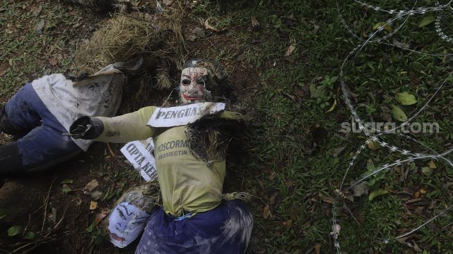 Sisa-sisa boneka yang dibakar oleh massa saat melakukan aksi unjuk rasa di kawasan Patung Kuda Arjuna Wiwaha, Jakarta, Kamis (10/12/2020). [Suara.com/Angga Budhiyanto]