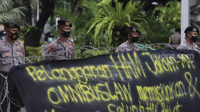 Aparat kepolisian melakukan penjagaan saat sejumlah massa melakukan aksi unjuk rasa di kawasan Patung Kuda Arjuna Wiwaha, Jakarta, Kamis (10/12/2020). [Suara.com/Angga Budhiyanto]