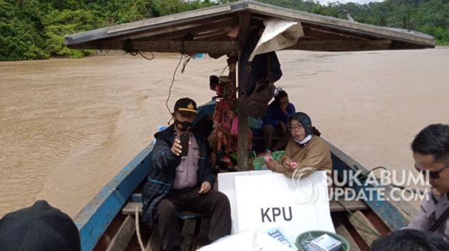 Petugas mengantarkan logistik Pilkada 2020 menggunakan perahu mengarungi Sungai Cikaso, Kecamatan Cibitung, Kabupaten Sukabumi. Logistik Pilkada ini untuk TPS 13 di Kampung Ciloma, Desa Cibitung, Kecamatan Cibitung. | Sumber Foto:Istimewa