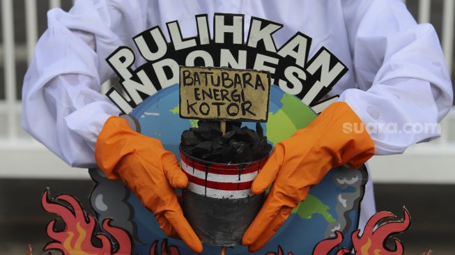 Aktivis Wahana Lingkungan Hidup Indonesia (Walhi) menggelar aksi di depan gedung Kementerian Energi dan Sumber Daya Mineral Republik Indonesia, Jakarta, Jumat (11/12/2020). [Suara.com/Angga Budhiyanto]