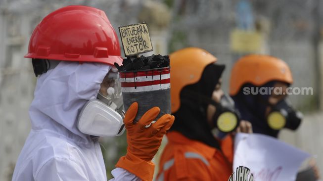 Aktivis Wahana Lingkungan Hidup Indonesia (Walhi) menggelar aksi di depan gedung Kementerian Energi dan Sumber Daya Mineral Republik Indonesia, Jakarta, Jumat (11/12/2020). [Suara.com/Angga Budhiyanto]