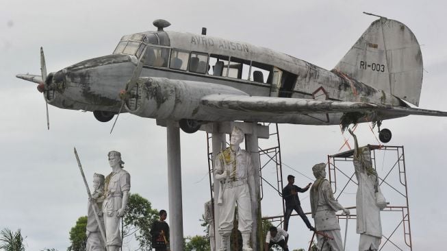 Pekerja membersihkan monumen pesawat Avro Anson RI-003 yang tidak terawat di Nagari Gaduik, Tilatang Kamang, Kabupaten Agam, Sumatera Barat, Jumat (11/12/2020).  [ANTARA FOTO/Iggoy el Fitra]