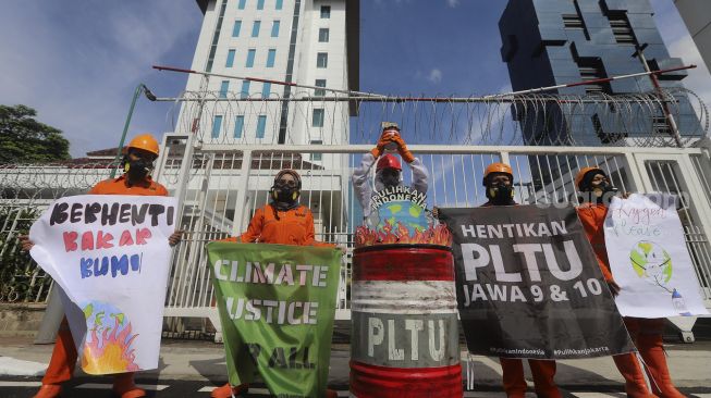 Aktivis Wahana Lingkungan Hidup Indonesia (Walhi) menggelar aksi di depan gedung Kementerian Energi dan Sumber Daya Mineral Republik Indonesia, Jakarta, Jumat (11/12/2020). [Suara.com/Angga Budhiyanto]