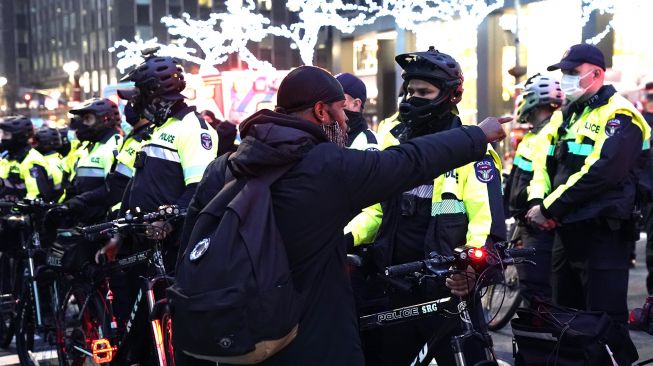 Seorang pengunjuk rasa berteriak pada petugas NYPD setelah sebuah mobil menabrak beberapa pengunjuk rasa Black Lives Matter pada 11 Desember 2020. [TIMOTHY A. CLARY / AFP]
