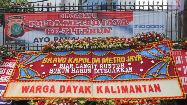 Salah satu karangan bunga dari warga Dayak Kalimantan yang menghiasi halaman depan Polda Metro Jaya, Jakarta Selatan, (12/12). [Suara.com/Alfian Winanto]