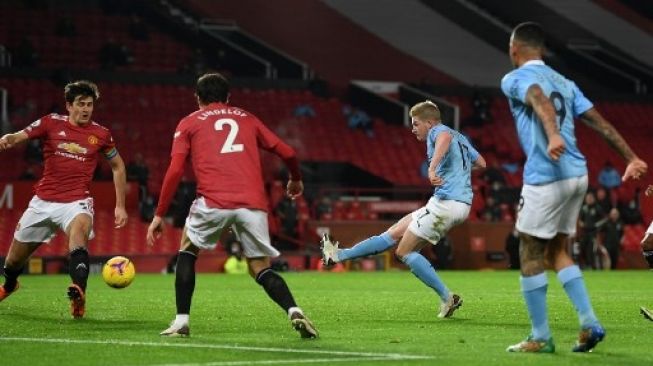 Pemain Manchester City Kevin De Bruyne melepaskan tembakan ke gawang Manchester United dalam pertandingan Liga Premier Inggris yang berlangsung di Old Trafford, Minggu (13/12/2020). [AFP]