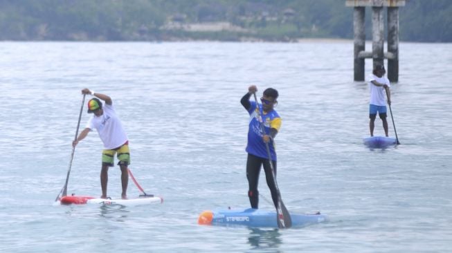 Peserta mengendalikan papan 'Stand Up Paddle' saat mengikuti kegiatan 'Stand Up for Bali' di kawasan Pantai Kelan, Badung, Bali, Minggu (13/12/2020). [ANTARA FOTO/Fikri Yusuf]