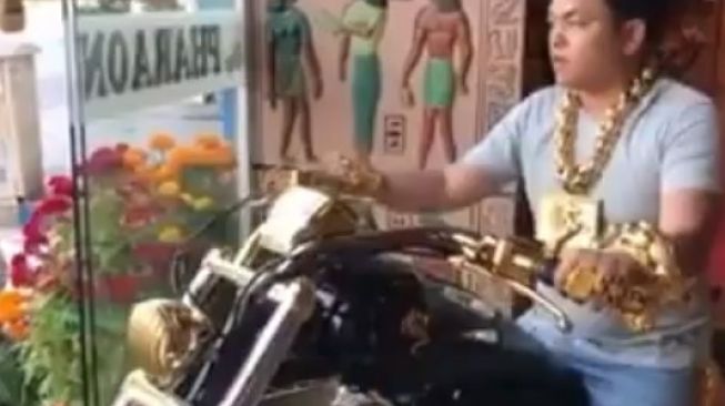 Pria dengan menggunakan gelang, kalung berbahan emas tampak sedang naik motor (Instagram)