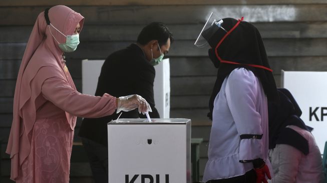 Warga memasukkan surat suara saat pelaksanaan pemungutan suara ulang (PSU) di TPS 11, Desa Kalukubula, Kecamatan Sigi Biromaru, Kabupaten Sigi, Sulawesi Tengah, Minggu (13/12/2020). [ANTARA FOTO/Mohamad Hamzah]