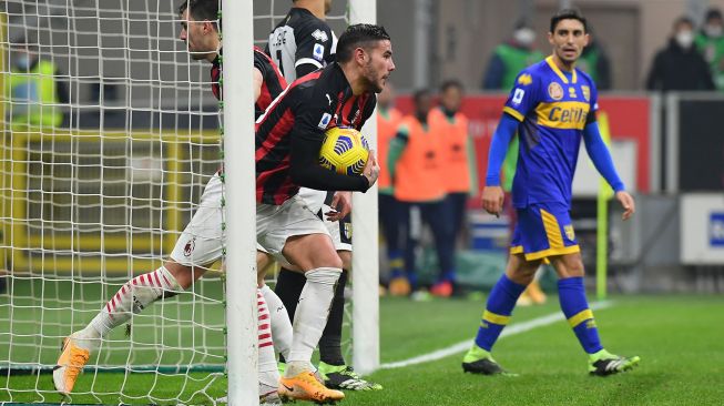 Pemain belakang AC Milan Theo Hernandez merebut bola setelah mencetak gol pertandingan sepak bola Serie A Italia AC Milan melawan Parma di stadion San Siro, Milan, Italia, Senin (14/12) dini hari WIB. 
Isabella BONOTTO / AFP