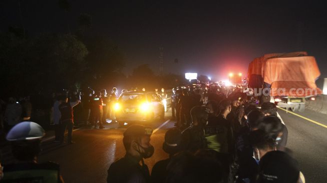 Tim Bareskrim Polri menggelar rekonstruksi kasus penembakan enam laskar pengawal Pimpinan FPI Rizieq Shihab di kilometer 50 tol Jakarta-Cikampek, Karawang, Jawa Barat, Senin (14/12/2020) dini hari. [Suara.com/Angga Budhiyanto]