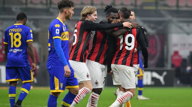 Bek AC Milan Theo Hernandez (kanan) merayakan golnya bersama gelandang AC Milan Franck Kessie dan rekan satu timnya setelah mencetak gol penyeimbang pada pertandingan sepak bola Serie A Italia AC Milan melawan Parma di stadion San Siro, Milan, Italia, Senin (14/12) dini hari WIB. [Isabella BONOTTO / AFP]
