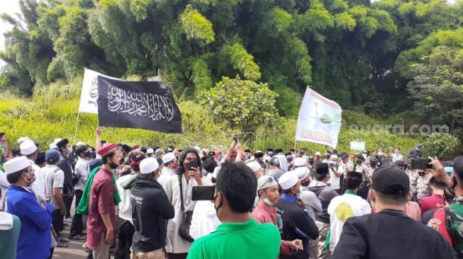 Massa aksi damai pecinta Habib Rizieq Shihab mulai bergerak menuju Polres Tangsel, Selasa (15/12/2020). [Suara.com/Wivy]