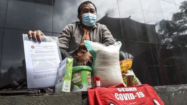 Koordinator Masyarakat Anti Korupsi Indonesia (MAKI) Boyamin Saiman menunjukkan sampel barang bukti berupa paket bantuan sosial (Bansos) COVID-19 yang akan diserahkan di Gedung Komisi Pemberantasan Korupsi (KPK), Jakarta, Rabu (16/12/2020).  [ANTARA FOTO/M Risyal Hidayat]