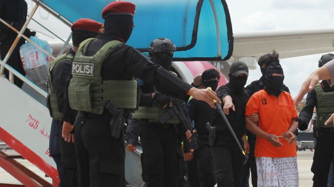 Petugas Detasemen Khusus (Densus) 88 membawa terduga teroris Arif Sunarso alias Zulkarnaen dari Lampung setibanya di Bandara Soekarno Hatta, Tangerang, Banten, Rabu (16/12/2020).  [ANTARA FOTO/Muhammad Iqbal]