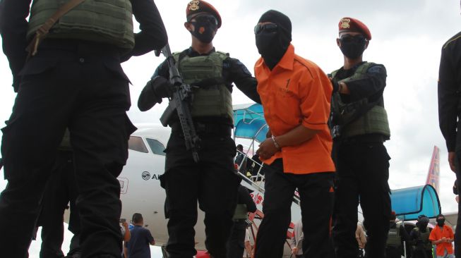 Petugas Detasemen Khusus (Densus) 88 membawa terduga teroris dari Lampung setibanya di Bandara Soekarno Hatta, Tangerang, Banten, Rabu (16/12/2020). [ANTARA FOTO/Muhammad Iqbal]