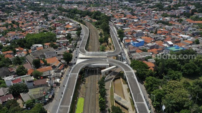 Foto udara sejumlah kendaraan melintas di dekat proyek pembangunan jalan layang tak sebidang tapal kuda Lenteng Agung, Jakarta, Rabu (16/12/2020). [Suara.com/Angga Budhiyanto]