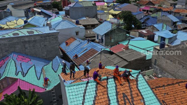 Foto udara petugas PPSU mengecat atap hunian warga di RT 012, RW 001 Kelurahan Lenteng Agung, Jagakarsa, Jakarta, Rabu (16/12/2020). [Suara.com/Angga Budhiyanto]