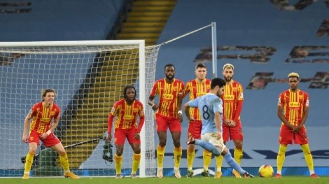 Pemain Manchester City Ilkay Gundogan melepaskan tendangan bebas ke gawang West Brom di Etihad Stadium dalam lanjutan Liga Premier Inggris, Rabu (16/12/2020). [AFP]