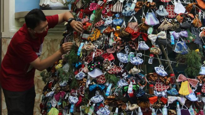 Warga menghias pohon Natal dengan masker di Gereja Katolik Kristus Raja, Surabaya, Jawa Timur, Rabu (16/12/2020).  ANTARA FOTO/Didik Suhartono