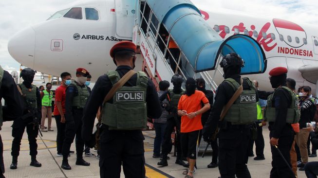 Petugas Detasemen Khusus (Densus) 88 membawa terduga teroris dari Lampung setibanya di Bandara Soekarno Hatta, Tangerang, Banten, Rabu (16/12/2020). [ANTARA FOTO/Muhammad Iqbal]