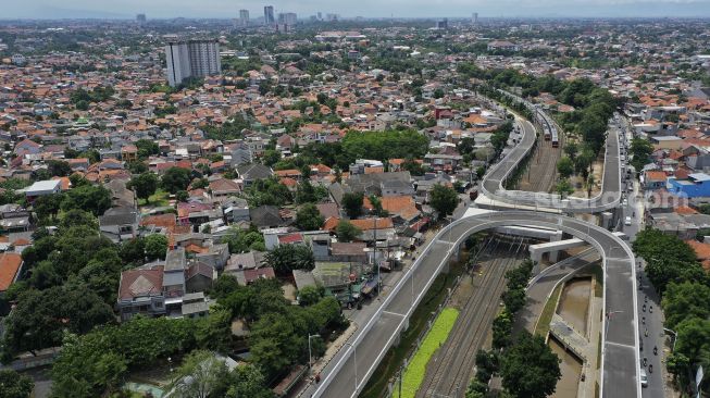 Foto udara sejumlah kendaraan melintas di dekat proyek pembangunan jalan layang tak sebidang tapal kuda Lenteng Agung, Jakarta, Rabu (16/12/2020). [Suara.com/Angga Budhiyanto]