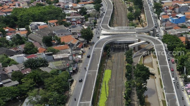 Foto udara sejumlah kendaraan melintas di dekat proyek pembangunan jalan layang tak sebidang tapal kuda Lenteng Agung, Jakarta, Rabu (16/12/2020). [Suara.com/Angga Budhiyanto]